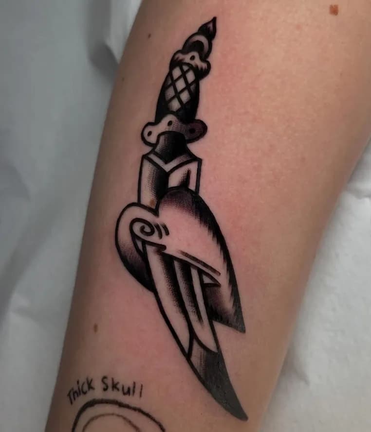 Black and grey traditional dagger tattoo, on the forearm
