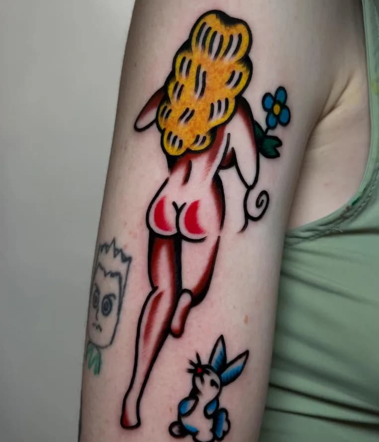 Traditional red pin-up girl tattoo with blonde hair, on the upper arm