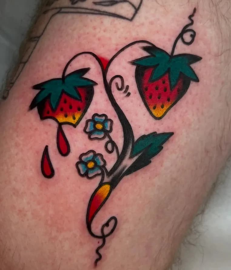 Traditional colorful strawberries tattoo with vine and flowers, on the leg